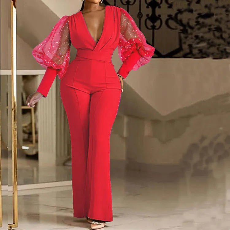 Red women's jumpsuit with mesh stitching, long sleeves, elastic waist, and wide-leg trousers laid flat.