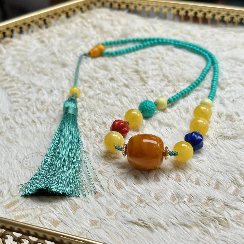 Turquoise stone pendant necklace with hand-woven mesh flower design on adjustable ball bead chain