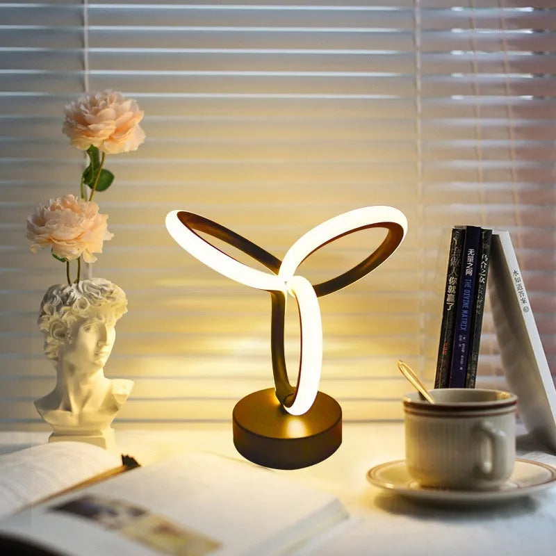 Black musical note shaped Bluetooth LED lamp with RGB colour changing lights on a table.