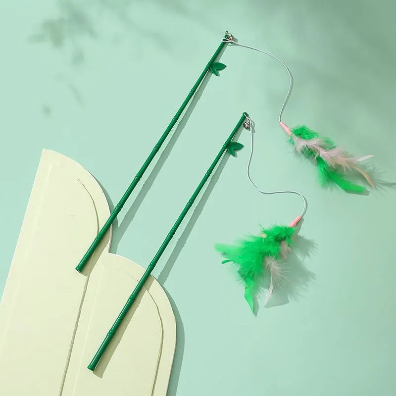 Green interactive cat feather wand toy with bells on a light background