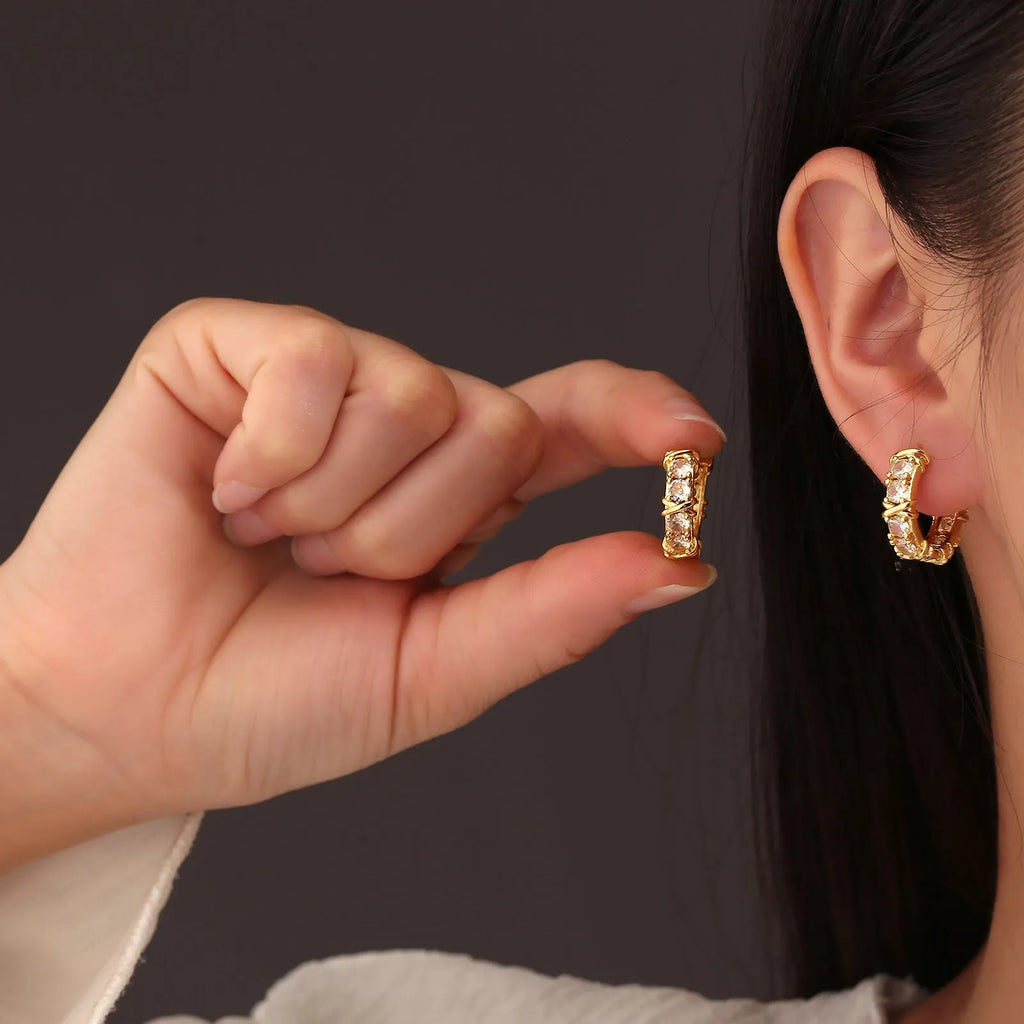 Geometric hexagonal clover cross shape earrings with ellipse detail, shown in gold and silver electroplated colours.