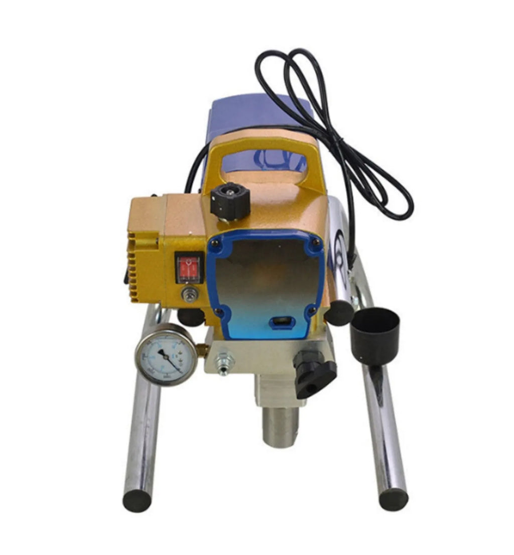 Blue portable electric airless spraying machine with spray gun, hose, extension rod, and accessories on a workbench