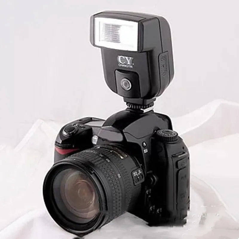 Silver hot shoe camera flash with head tilted upwards, shown mounted on an SLR camera.