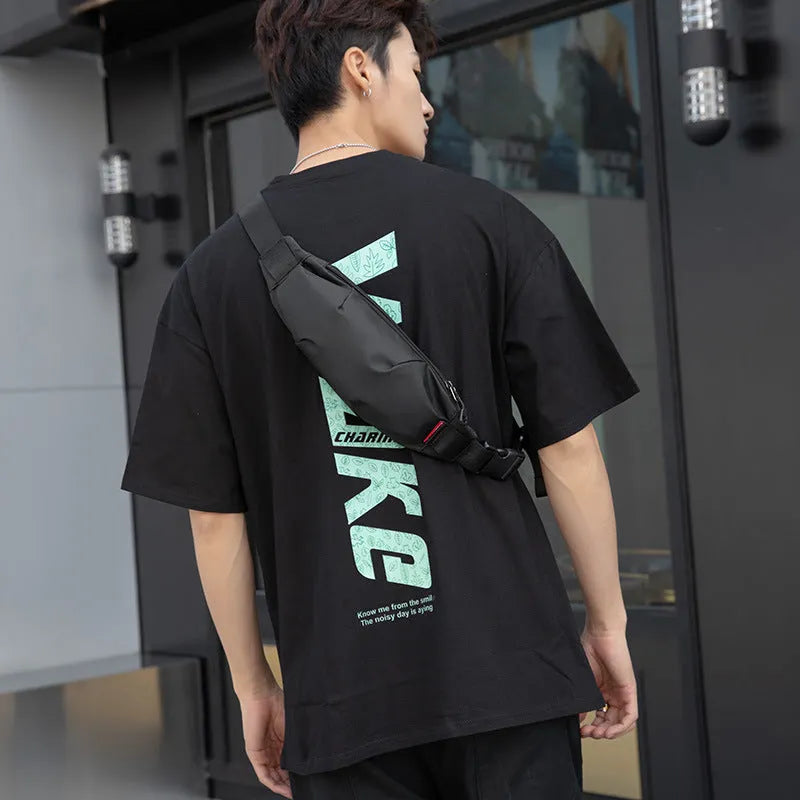 Black Oxford cloth waist pack showing front zipper and compact rectangular shape.
