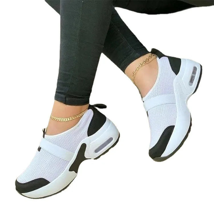 Women's white mesh flat sneakers with rubber sole and round toe on a light background