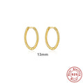 Close-up of a pair of twisted string round sterling silver earrings with gold plating.