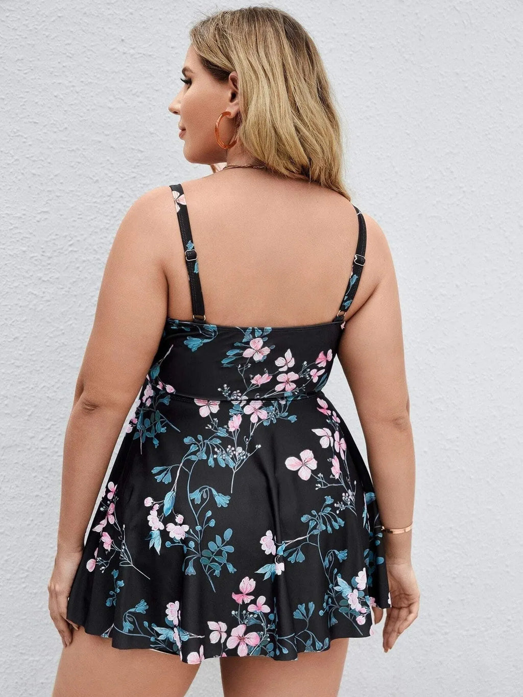 Women's floral print one-piece swimsuit on hanger, showing split colour design.
