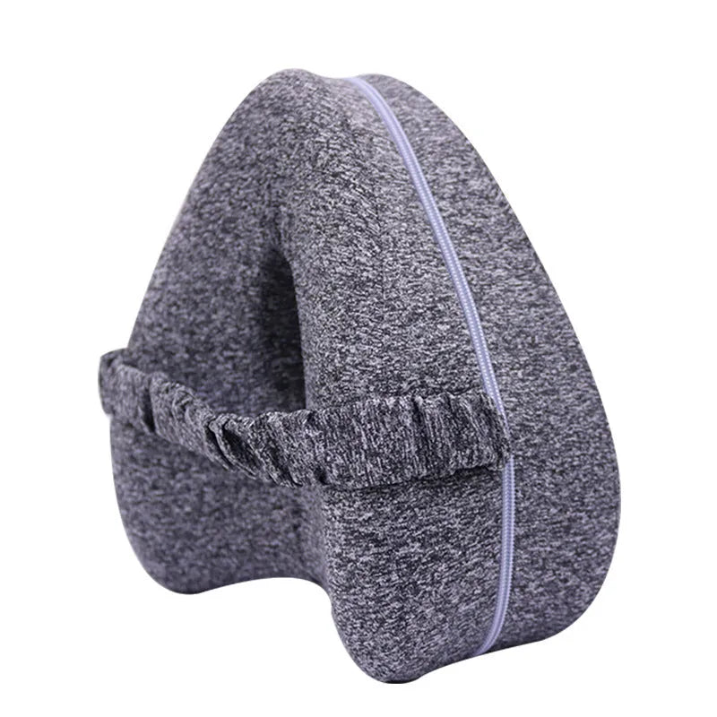 Heart-shaped dark blue jacquard memory foam leg pillow for adults on a bed.