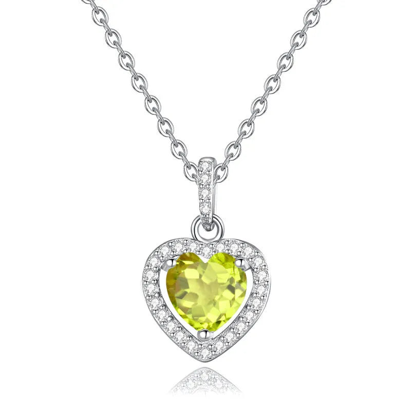 Sterling silver heart pendant necklace with inlaid gemstone on a cross chain, adjustable length.