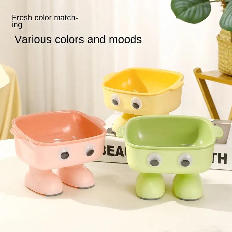 Green elevated cat bowl with robot shape design on anti-slip base showing tilted angle for feeding