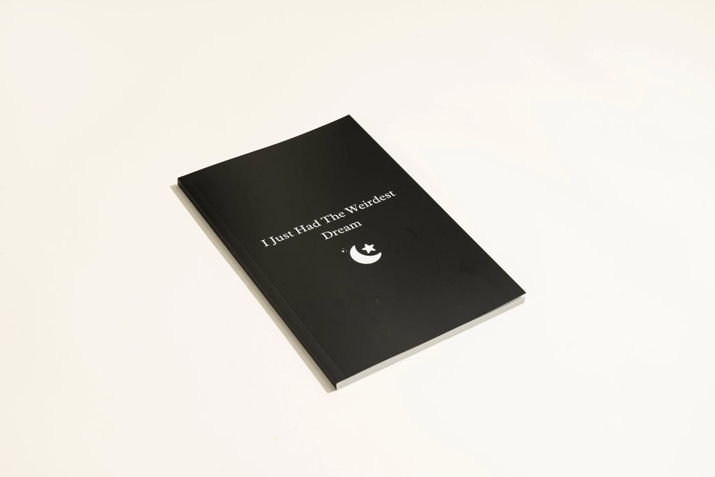 Black hardcover Dream Journal notebook for recording dreams and personal reflections.