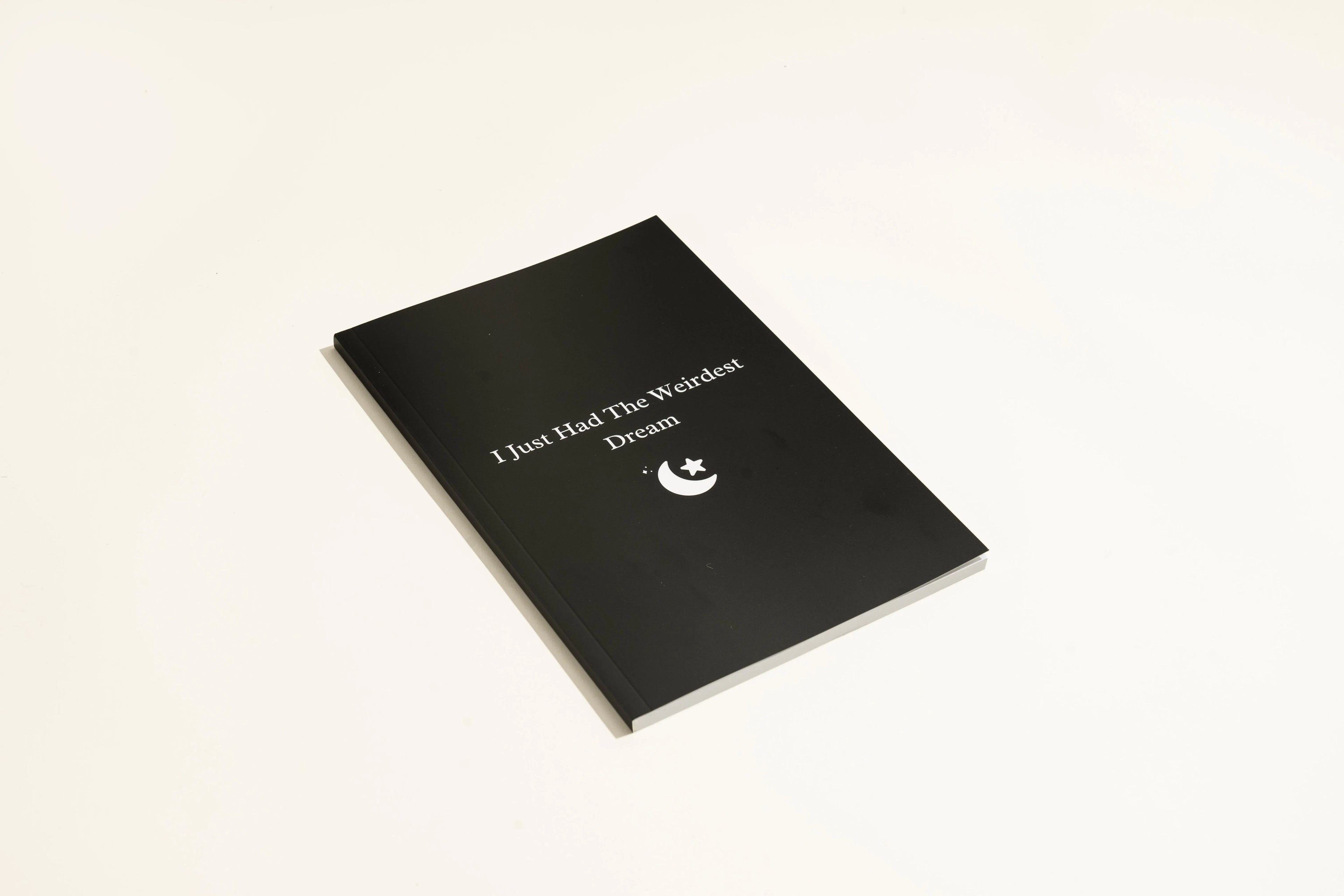 Black hardcover Dream Journal notebook for recording dreams and personal reflections.