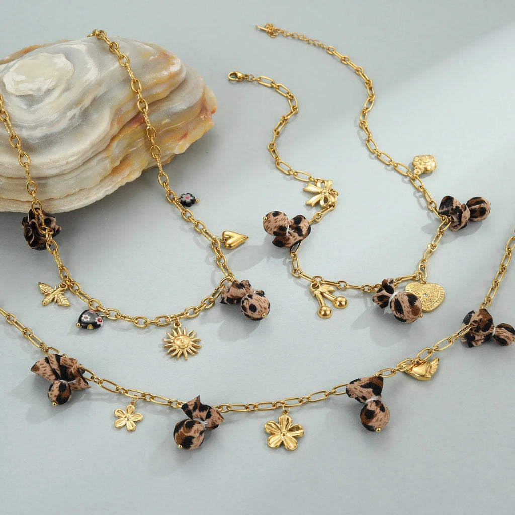 Stainless steel necklace with geometric pendant showing leopard spots, love hearts and flowers in gold finish