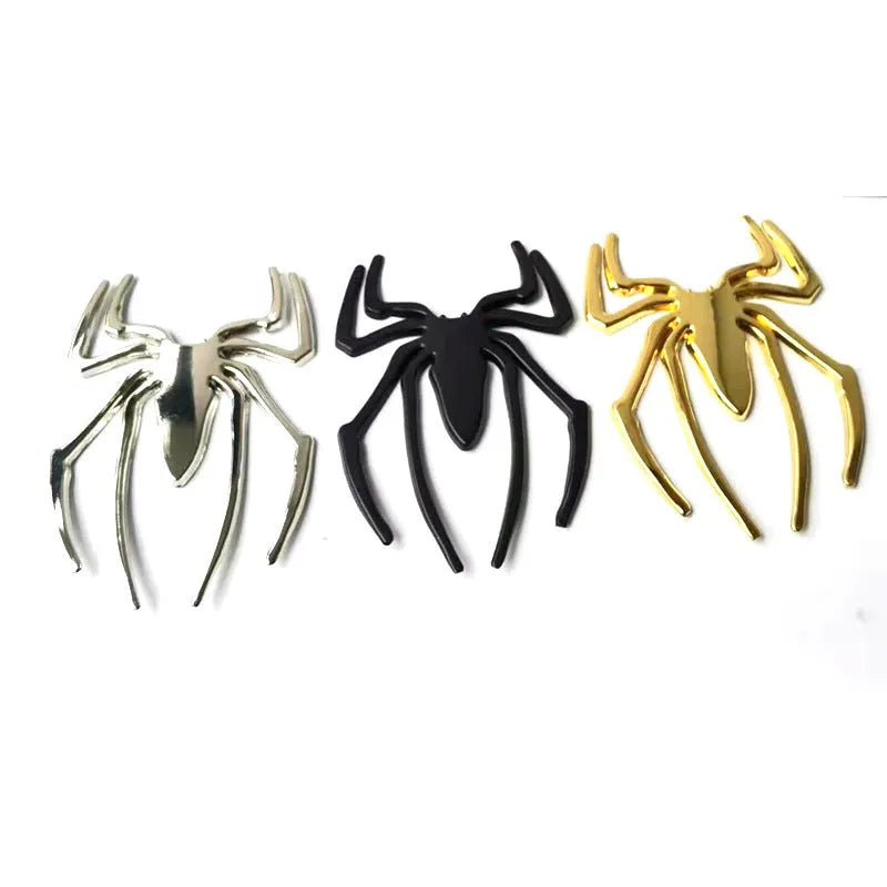 Three-dimensional metal spider bumper sticker in metallic finish on a car bumper.
