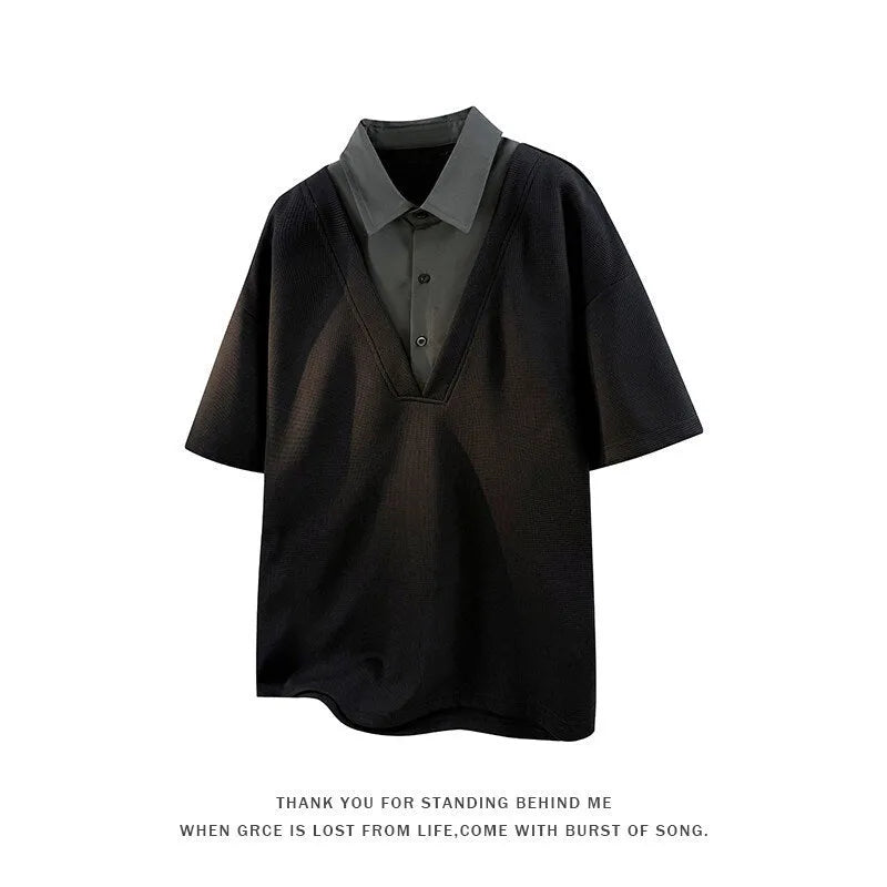 Man wearing a black heavy Henry collar polo shirt sweater with padded shoulders and short sleeves.