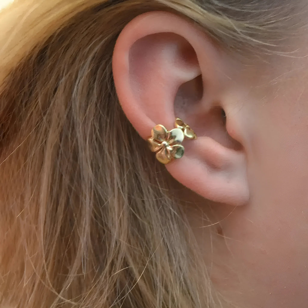 Women's gold starfish and conch shell drop earrings on white background