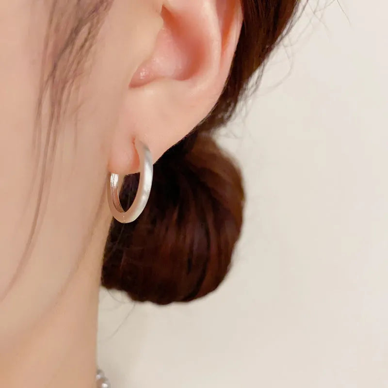 Geometric circle ear clips with gold plating and eyelet detail for women's pierced ears