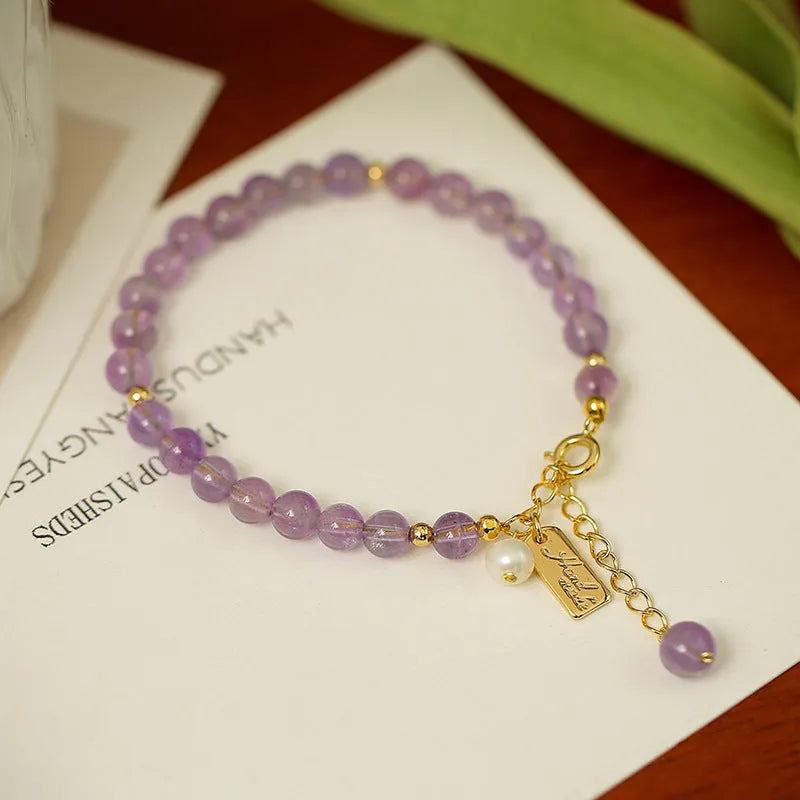 Natural crystal bracelet with romantic lavender amethyst beads, available in dark or light colour, on a plain background