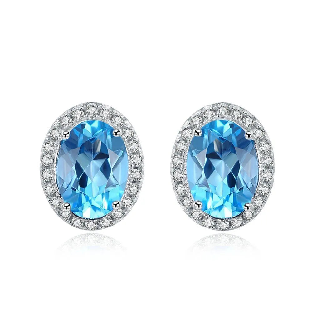 Women's sterling silver jewellery set with blue topaz gems featuring geometric earrings, ring, necklace and pendant