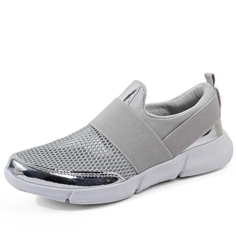 Blue women's low-top casual sneakers with mesh lining on a hard floor surface.