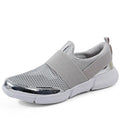 Blue women's low-top casual sneakers with mesh lining on a hard floor surface.