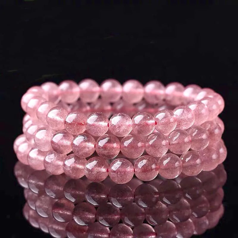 Close-up of a women's bracelet with polished strawberry quartz crystal beads in natural tones.