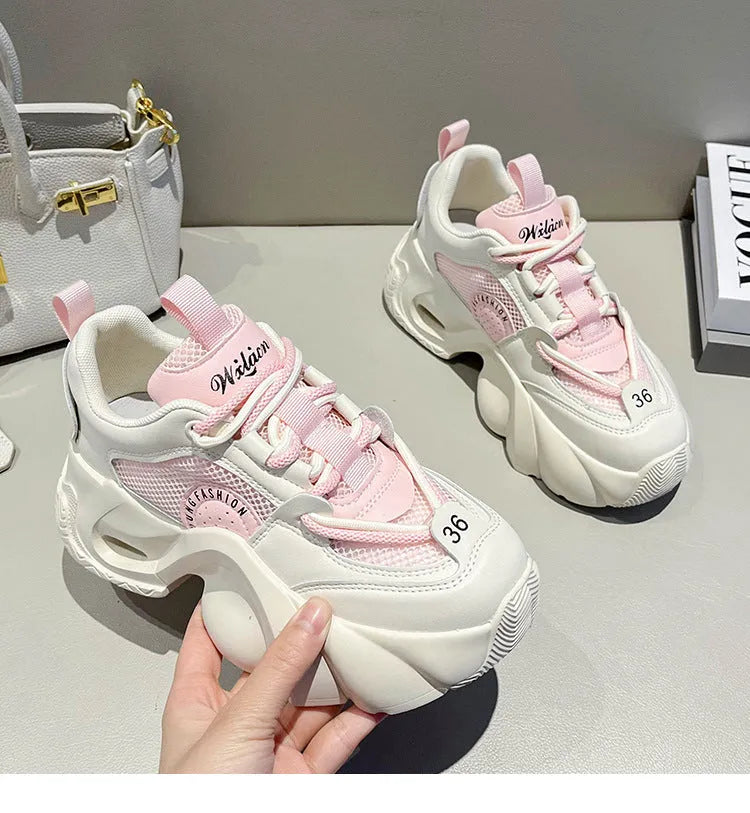 Women's pink casual sneakers with cross shoulder straps, thick sole, and mesh lining on a white background.