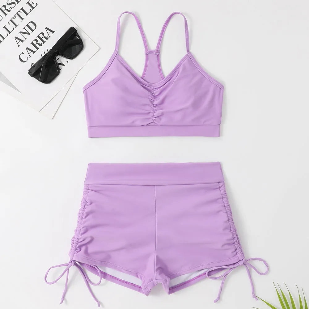 Women's high-waist split bikini swimsuit in solid black and purple colours showing two-piece design