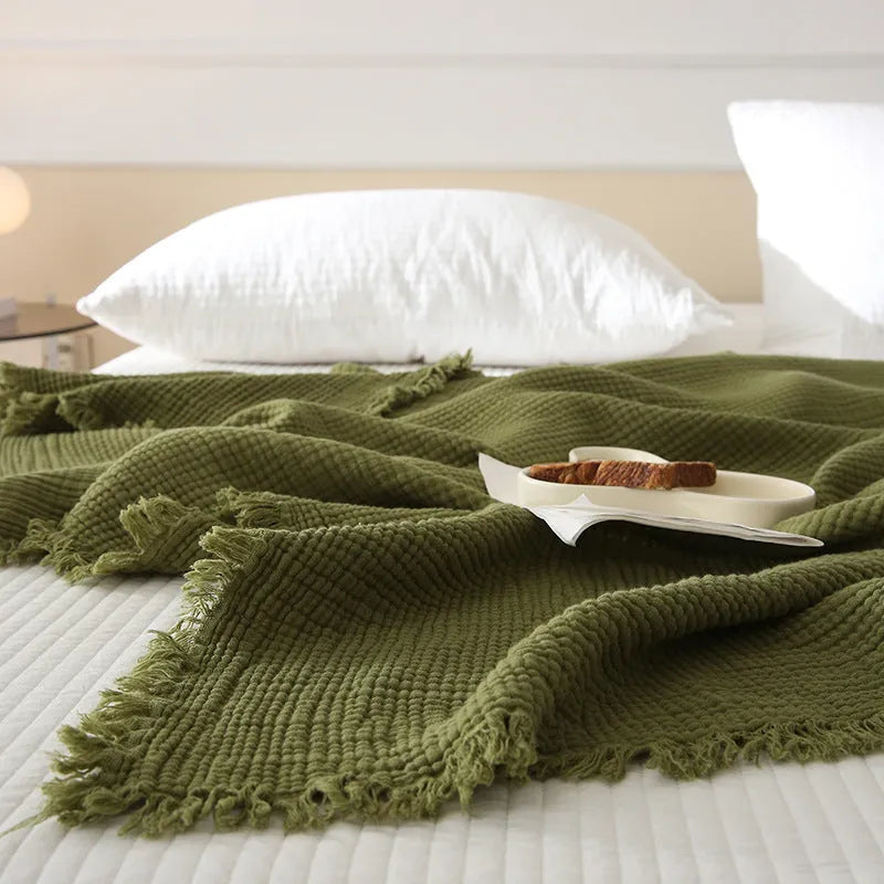 Cotton four-layer gauze throw blanket with tassel edges shown in avocado green colour.