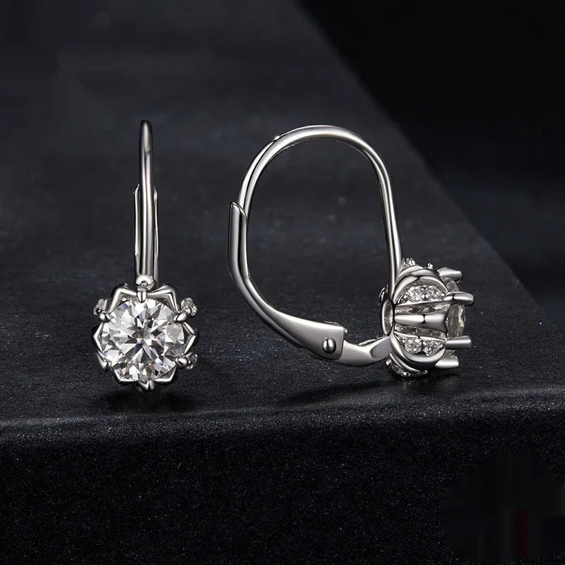 Close-up of a sterling silver floral bud ear clip with a moissanite stone and white gold plating.