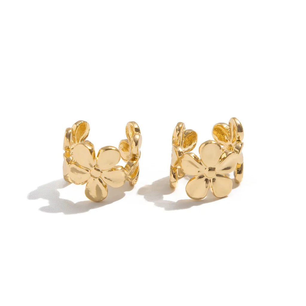 Women's gold starfish and conch shell drop earrings on white background