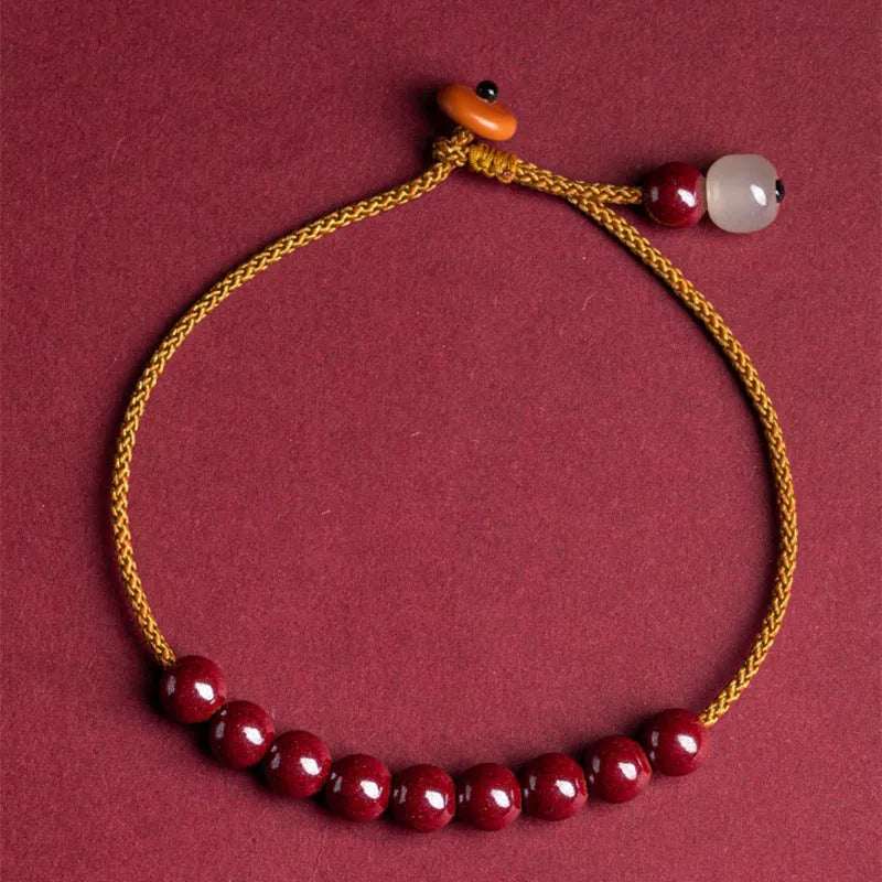 Hand-woven cinnabar and Hetian jade geometric bracelet on display