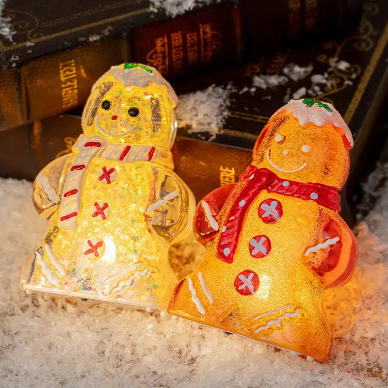 Glowing LED gingerbread man snowman Christmas ornament with a red scarf on a festive tree.