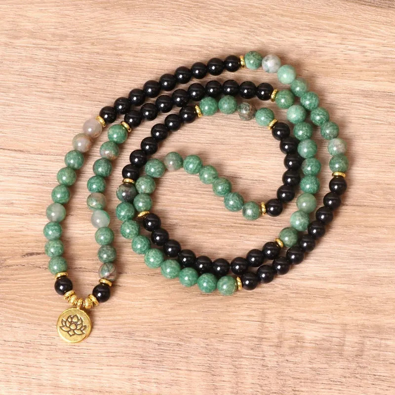 Green and black alloy bead elastic long bracelet on wrist.