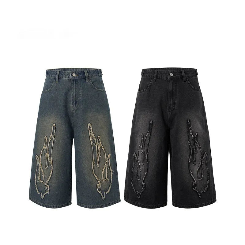 Men's black denim shorts with cropped length and flame embroidery patches on the leg.