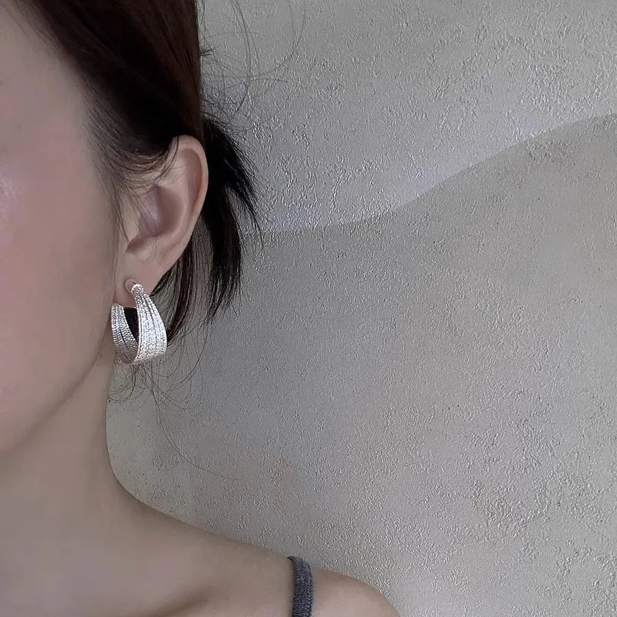 Geometric multi-layer copper earrings with an electroplated silver or gold finish, shown as studs and clips.
