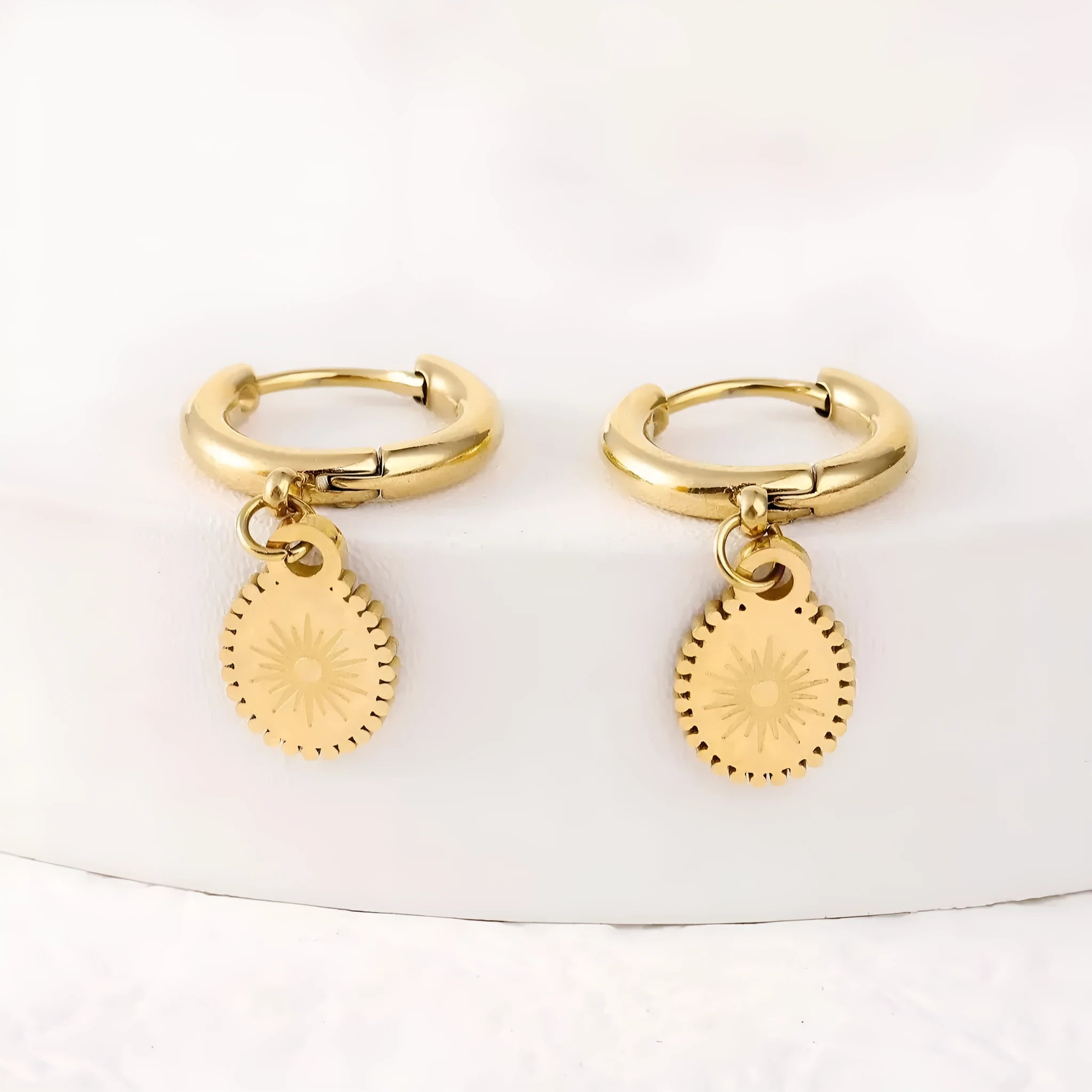 A pair of stainless steel geometric ear button earrings with an ellipse detail, style XY-EH005.