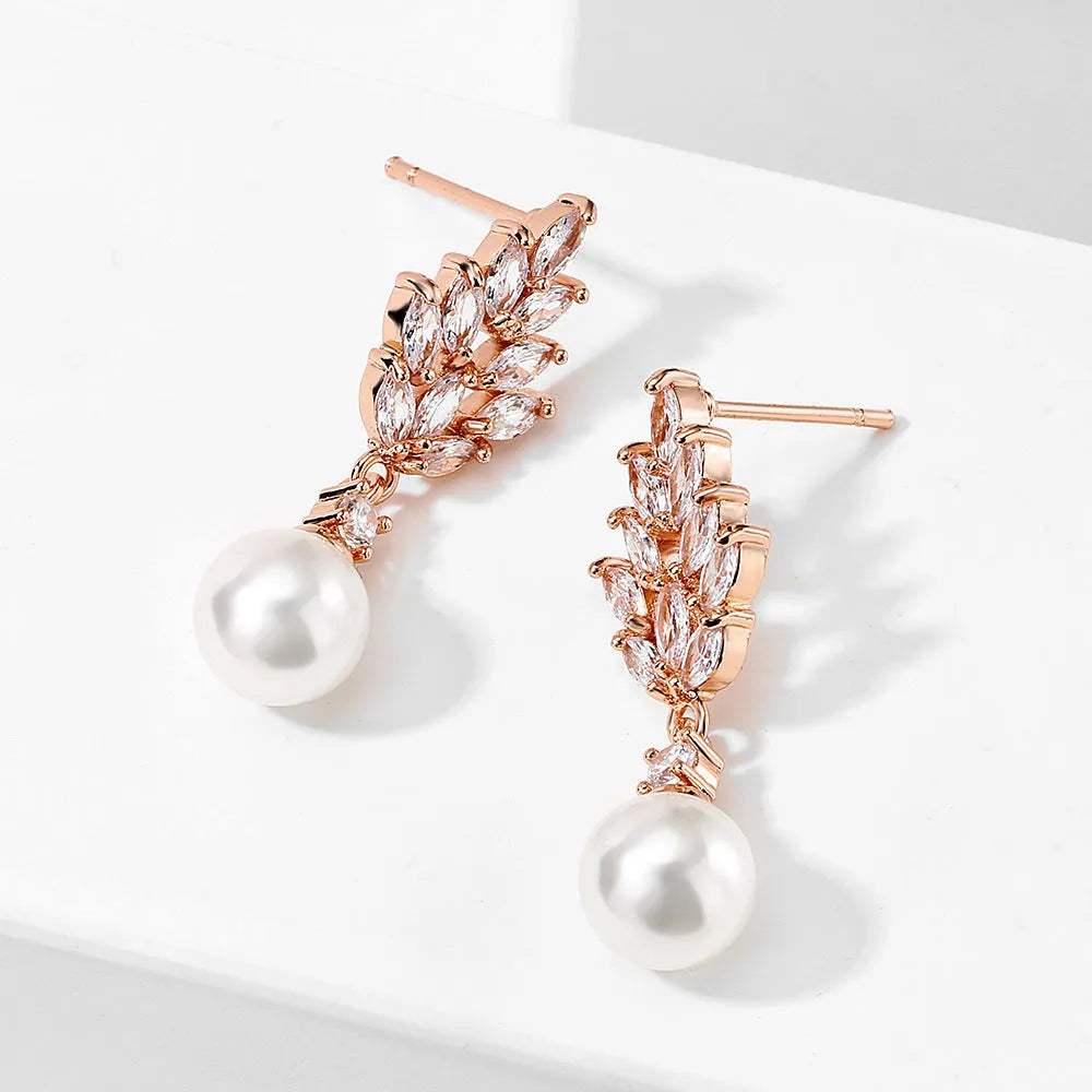 Geometric flower shaped earrings with micro inlaid zircon stones and pearl details on gold plating.