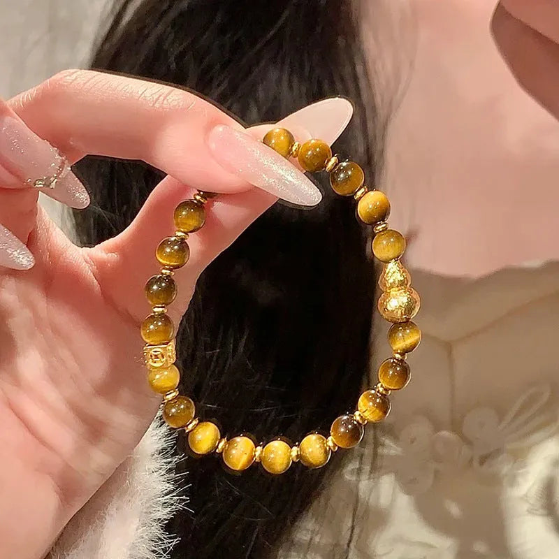 Natural yellow tiger's eye Hetian jade bracelet with diamond polish and auspicious pattern on white background
