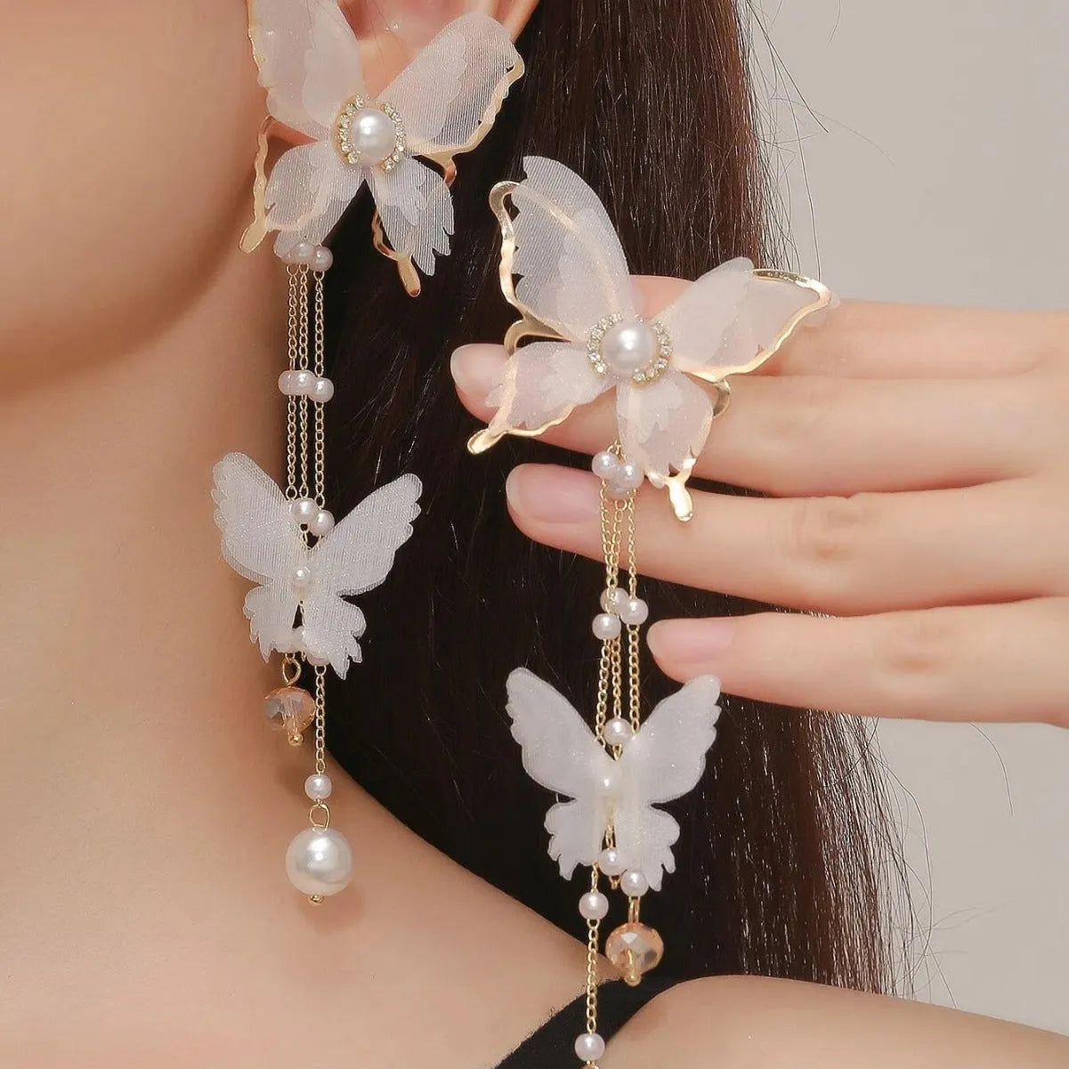 White butterfly-shaped earrings with tassel design featuring lace patterns, pearls, and rhinestones
