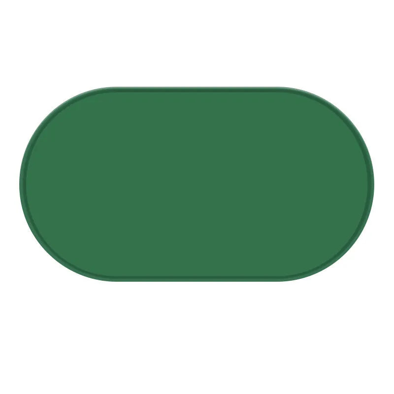 Green silicone waterproof placemat for cat bowls on a wooden floor.
