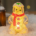 Glowing LED gingerbread man snowman Christmas ornament with a red scarf on a festive tree.