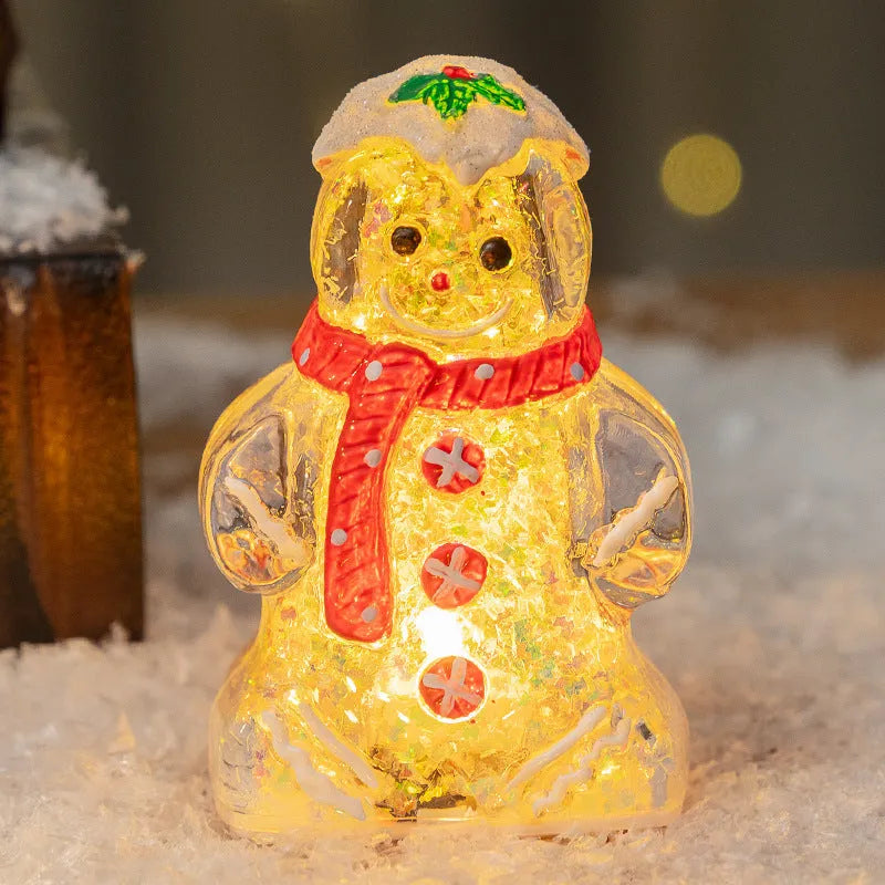Glowing LED gingerbread man snowman Christmas ornament with a red scarf on a festive tree.