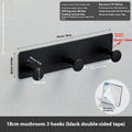Iron screwless wall hook with multiple hooks mounted with adhesive tape on a glass shower door.