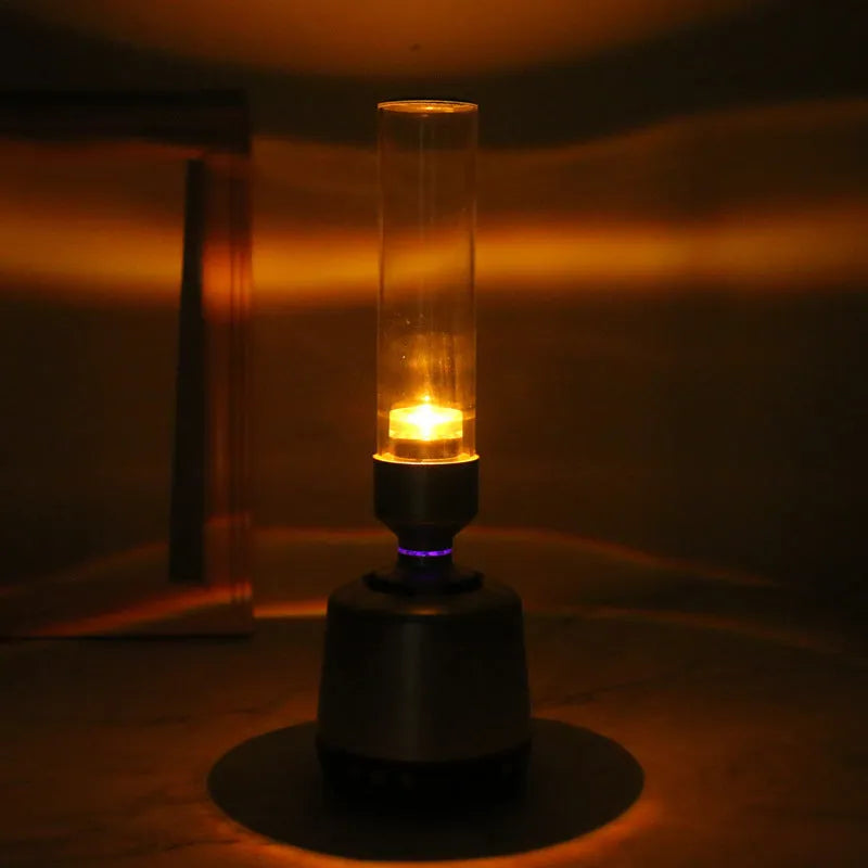 White silver candlelight Bluetooth speaker and night light on a table, showing modern cylindrical design.
