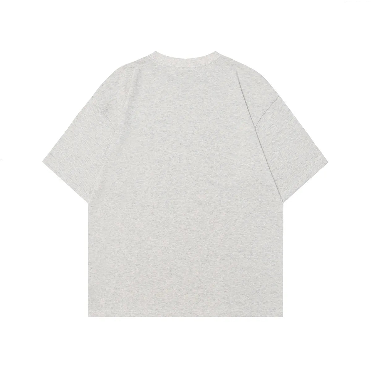 Man wearing a loose-fit grey t-shirt with a retro character print design on the front.