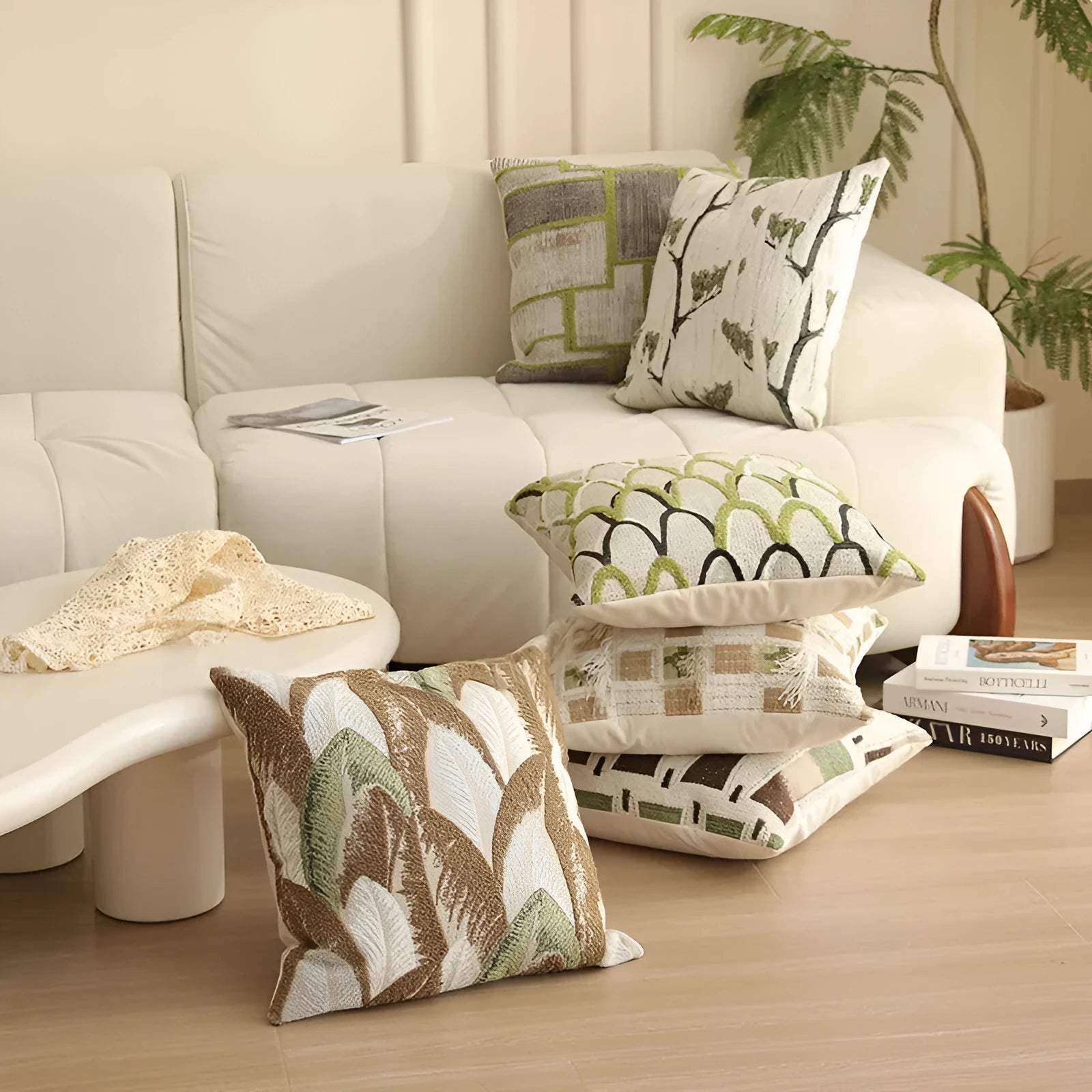 Square jacquard cushion cover with woven floral pattern on a grey sofa, showing zip closure and textured fabric.