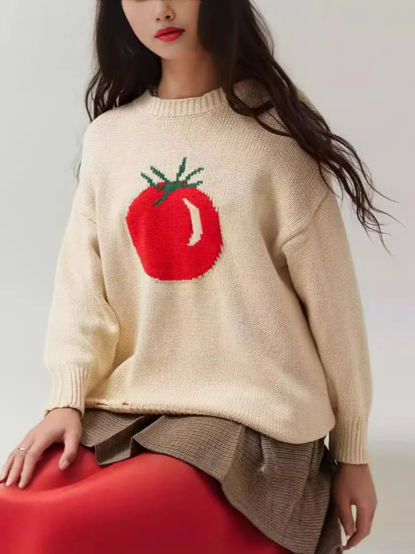 Women's loose-fitting beige jacquard knit sweater on a hanger, showing round neck and long sleeves.