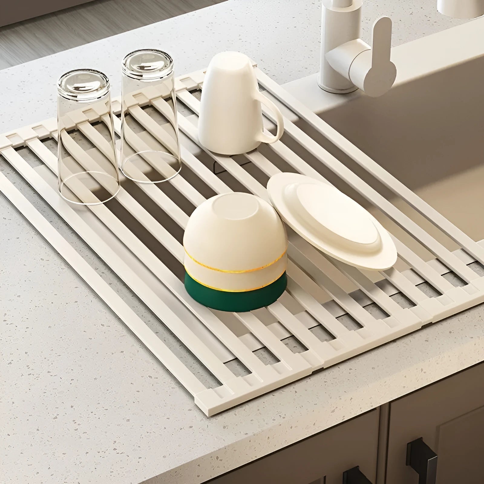 Foldable milky white stainless steel kitchen draining rack next to a sink.