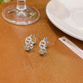 A pair of women's diamond-look fashion earrings with thick gold plating, shown in silver, gold, and rose gold colour options.
